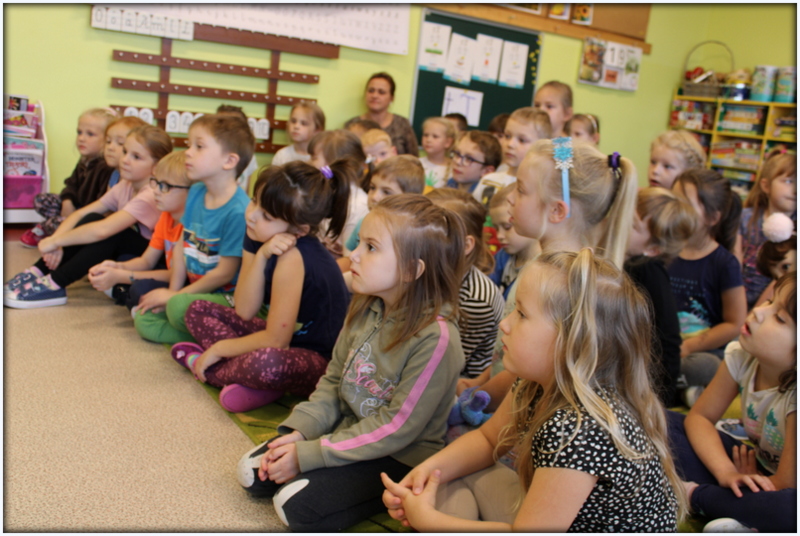 Przedszkolaki z zainteresowaniem przysłuchują się czytanemu opowiadaniu.