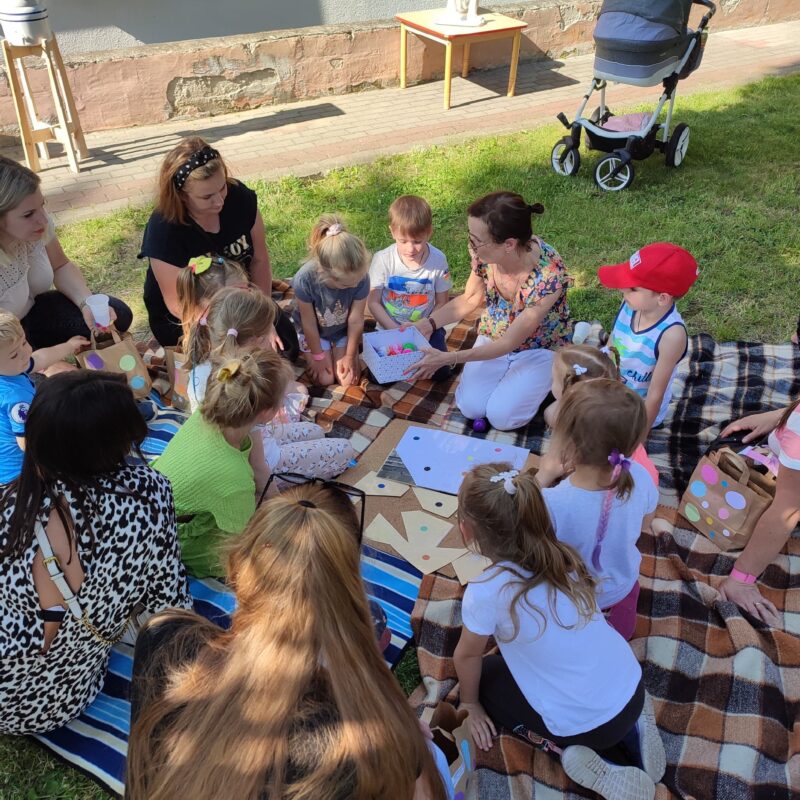 Przedszkolaki rozwiązują zadania podczas pikniku