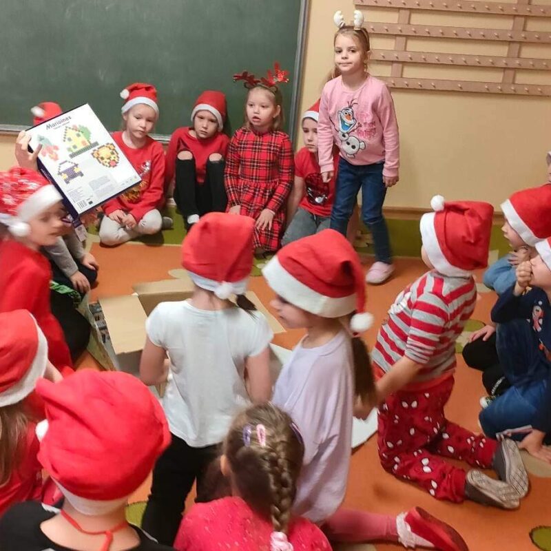 Przedszkolaki odpakowują prezenty od św. Mikołaja