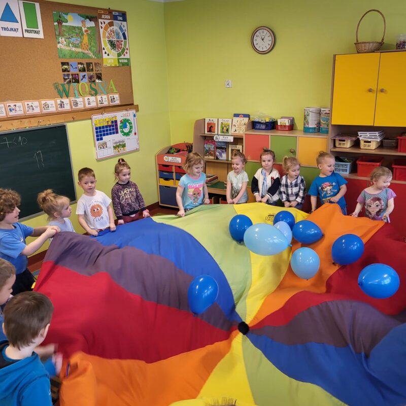 Grupa Krasnoludki podczas zabawy z chustą animacyjną i niebieskimi balonami
