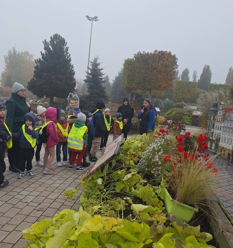 Przedszkolaki podczas spaceru po parku miniatur z przewodnikiem