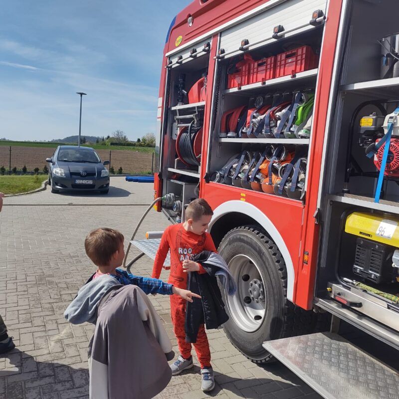 przedszkolaki oglądają wyposażenie wozu strażackiego