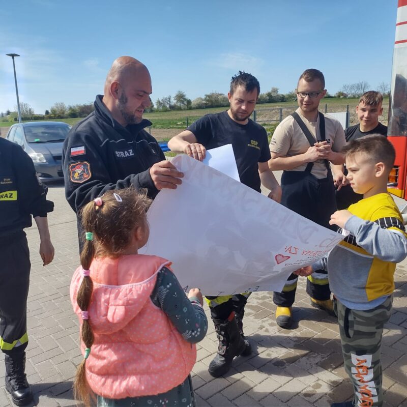 przedszkolaki wręczają podziękowanie strażakom